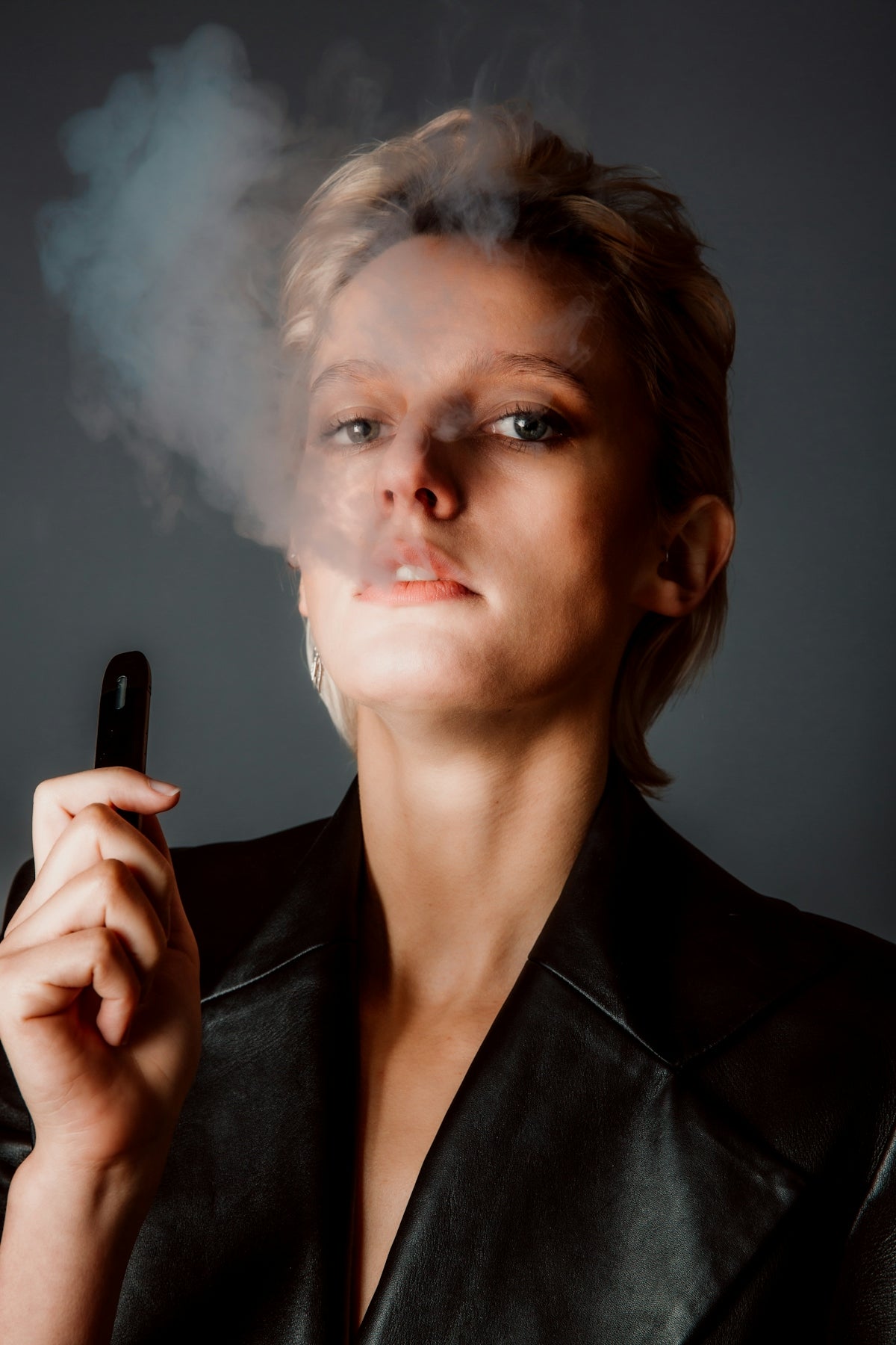 woman in black blazer holding phone