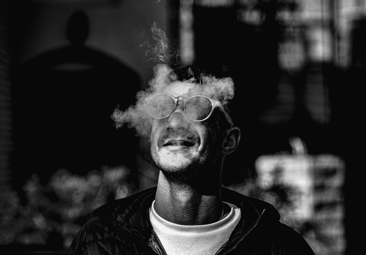 a man smoking a cigarette in a black and white photo