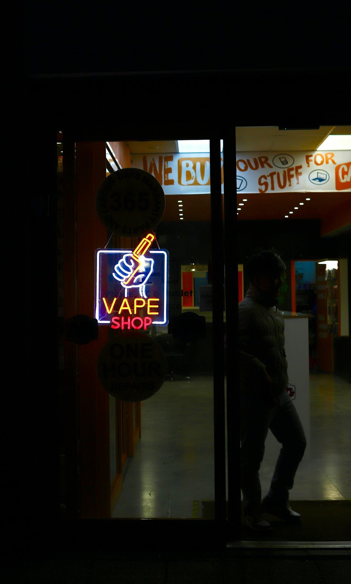 Neon vape shop sign with a silhouette of a person