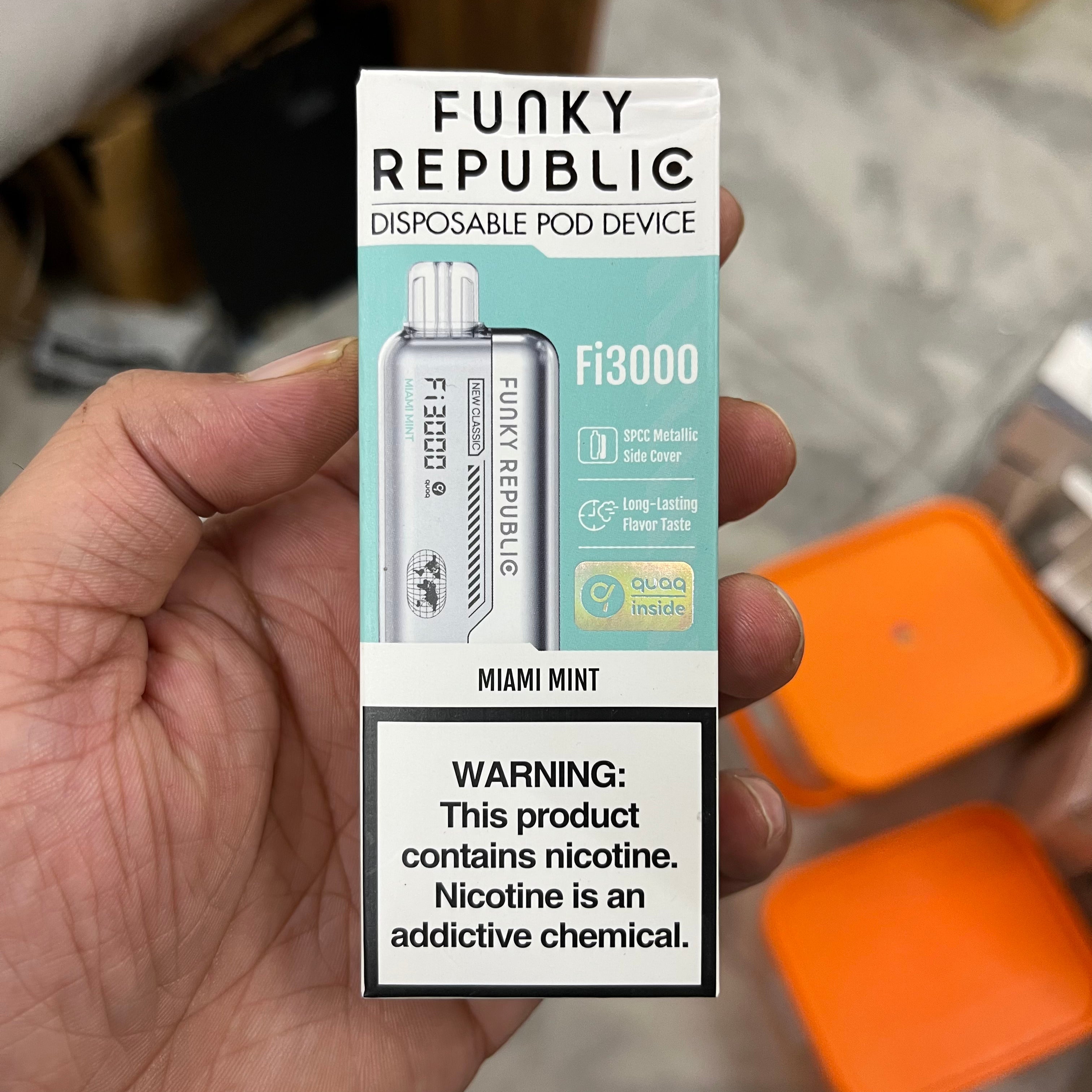 Funky Republic disposable pod device packaging held in a hand with a blurred background